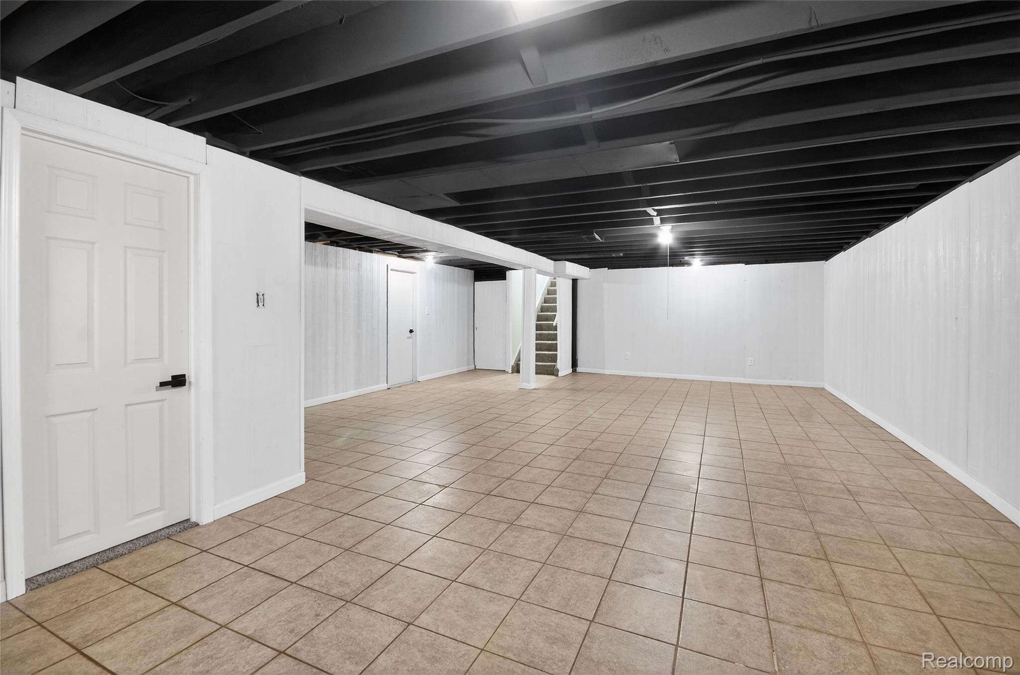 24065 Rockingham Street Southfield, MI 48033 - Photo 28 of 35 Finished basement with stairs and light tile patterned floors