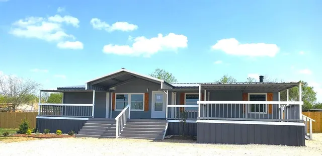 a view of a house with a deck and a yard