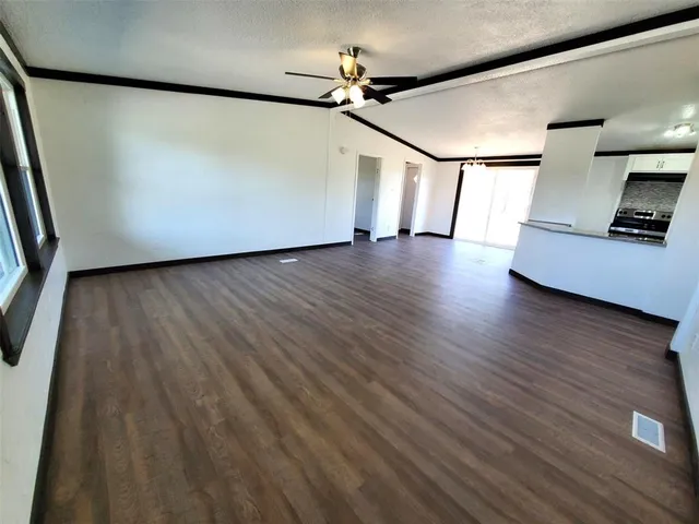a view of a livingroom with wooden floor and a ceiling fan