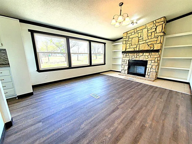 wooden floor fireplace and windows in an empty room