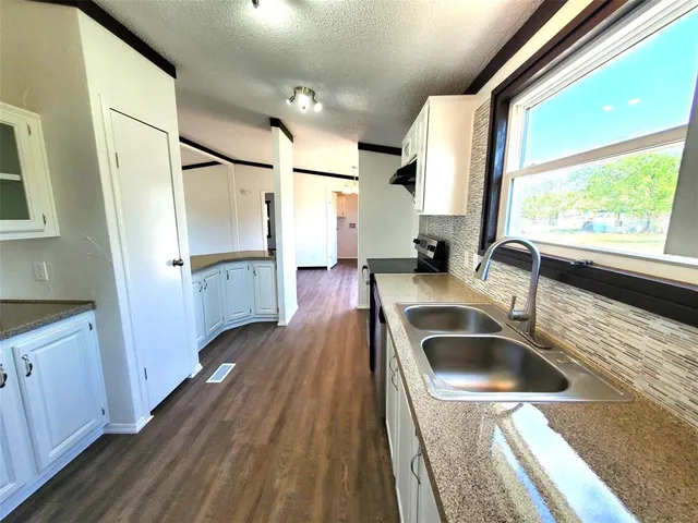 a kitchen with a sink and large mirror
