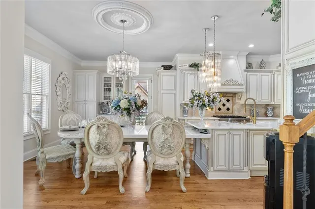 a living room with stainless steel appliances kitchen island granite countertop a table chairs in it and a large window