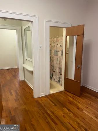 a view of empty room with wooden floor