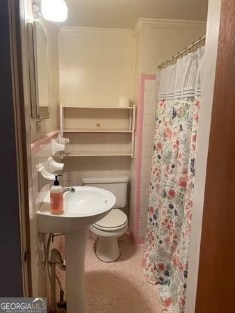 an empty room with chandelier fan and windows