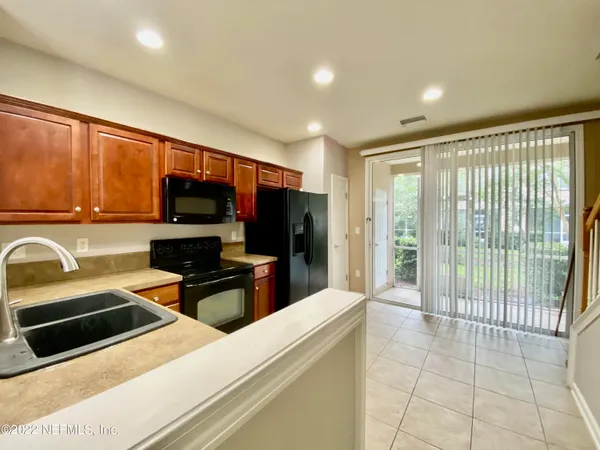 a kitchen with granite countertop a refrigerator and a stove top oven