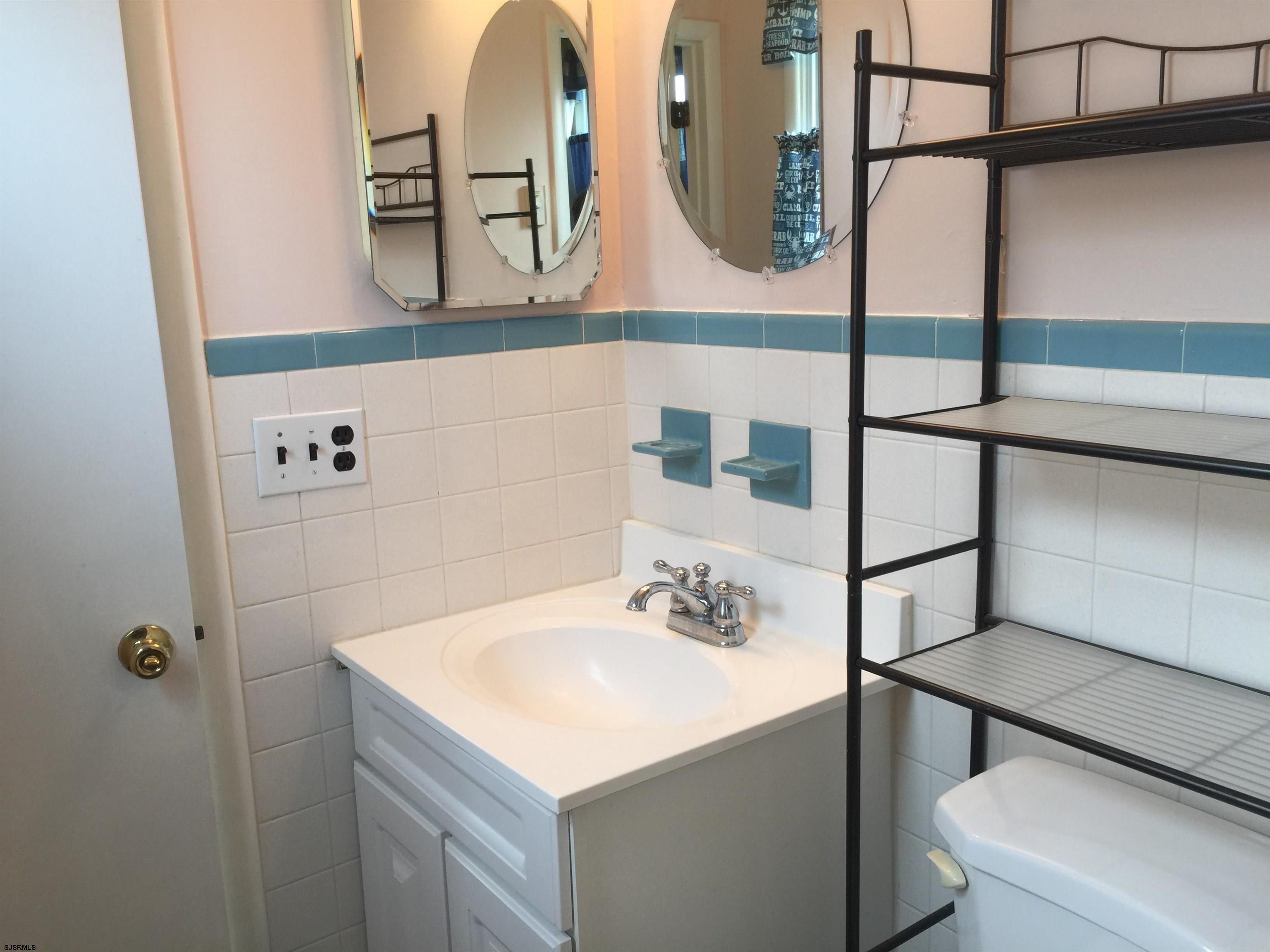 4632 Schooner Road, Unit 1 Brigantine, NJ 08203 - Photo 11 of 16 a bathroom with a sink a toilet and a mirror