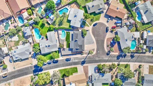 an aerial view of a house with a yard and a large tree
