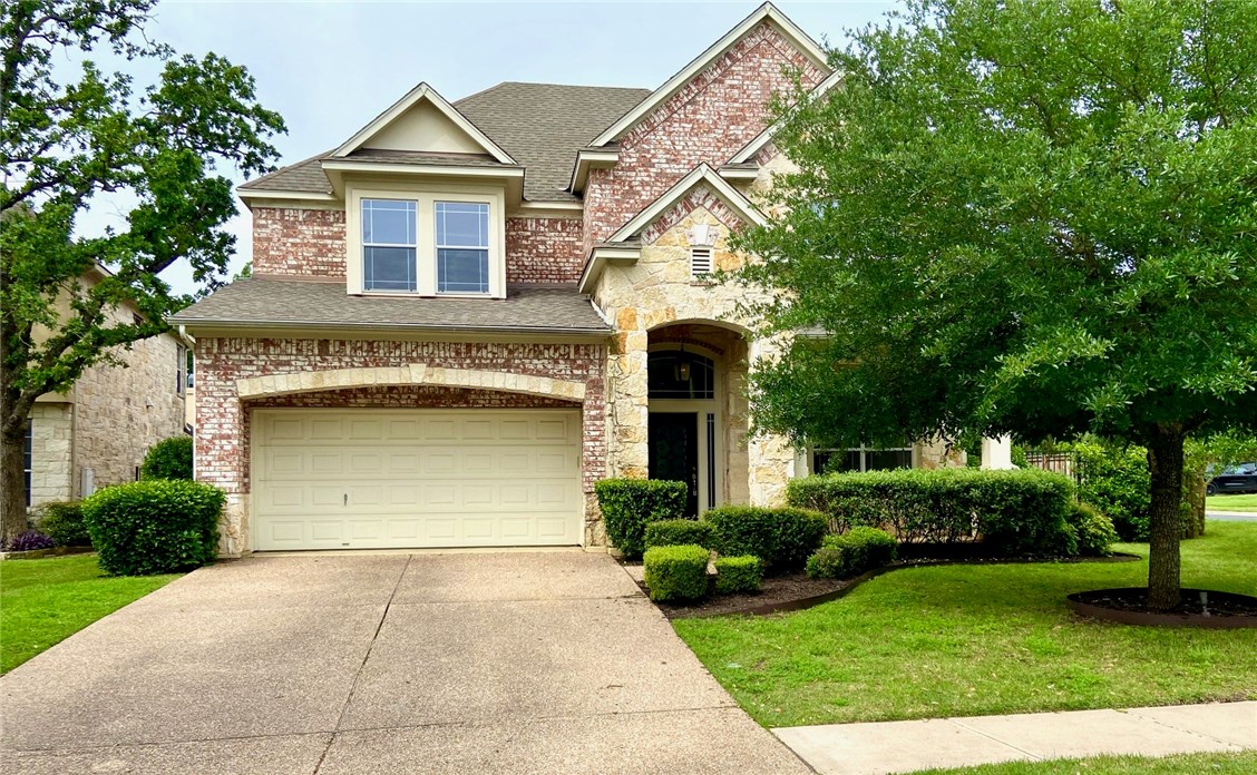 a front view of a house with a yard and garage