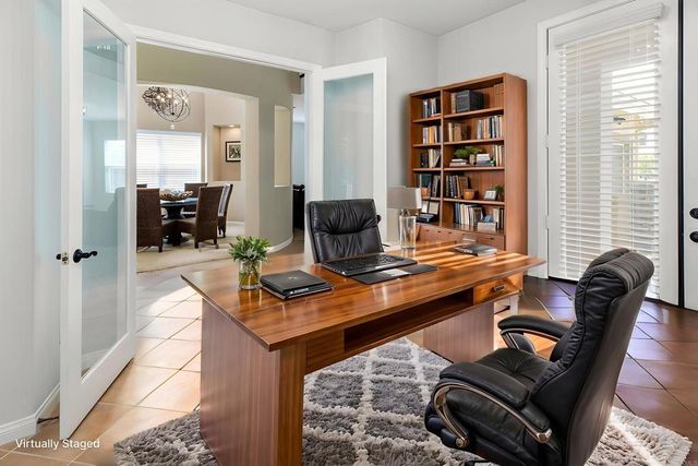 a view of a workspace with furniture and a window