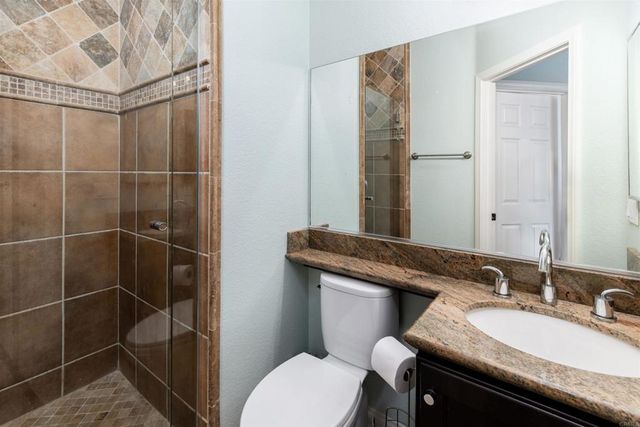 a bathroom with a sink toilet vanity and shower