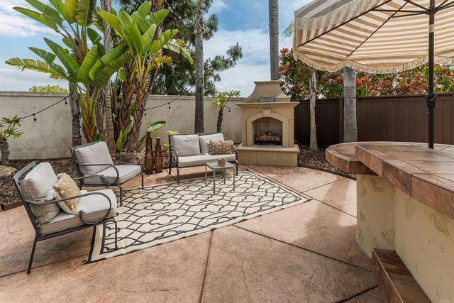 a living room with furniture a fireplace and a potted plant