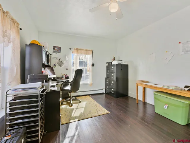 a view of a workspace with furniture and wooden floor
