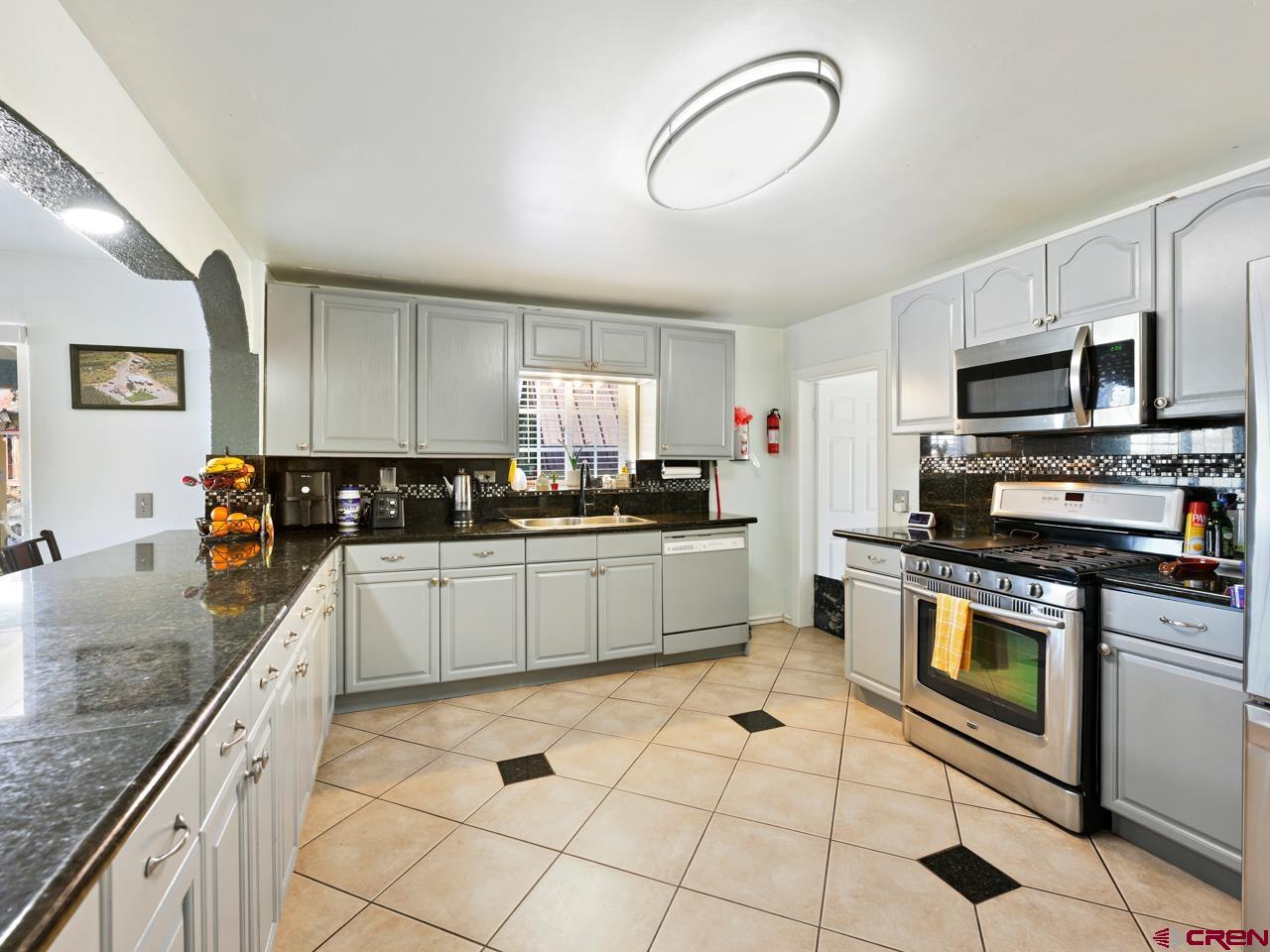 20809 Nowhere Road Eckert, CO 81418 - Photo 9 of 45 a kitchen with stainless steel appliances granite countertop a stove a sink and a microwave