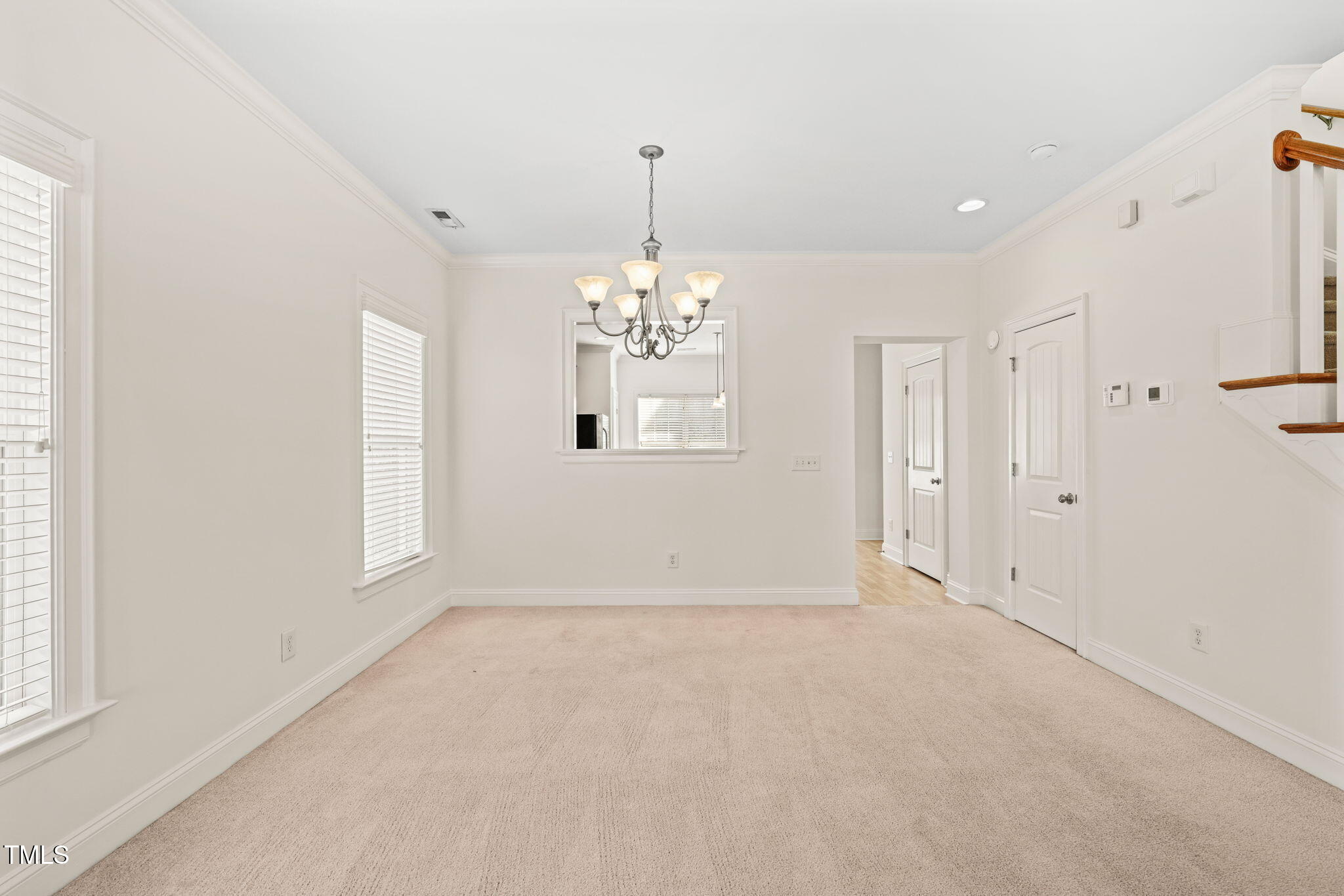 7732 ACC Boulevard Raleigh, NC 27617 - Photo 13 of 32 an empty room with chandelier and windows