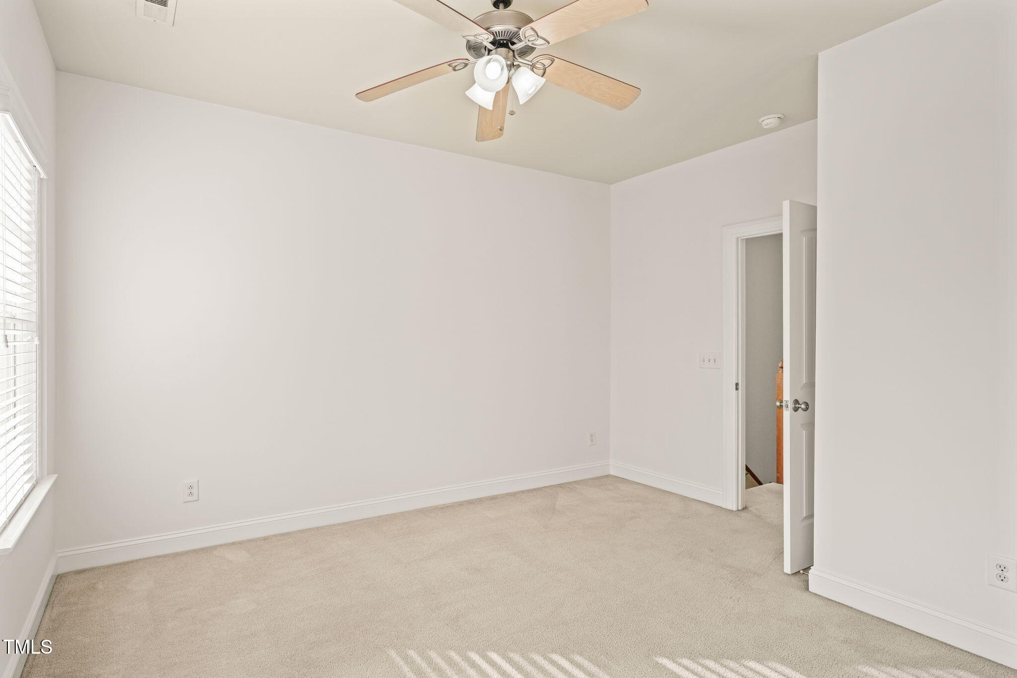 7732 ACC Boulevard Raleigh, NC 27617 - Photo 22 of 32 an empty room with a window and a fan
