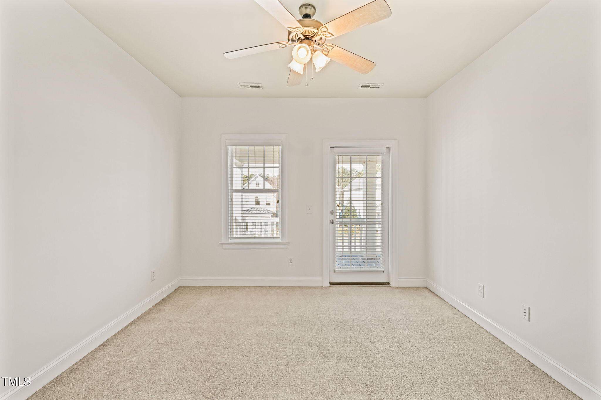 7732 ACC Boulevard Raleigh, NC 27617 - Photo 25 of 32 an empty room with chandelier fan and windows