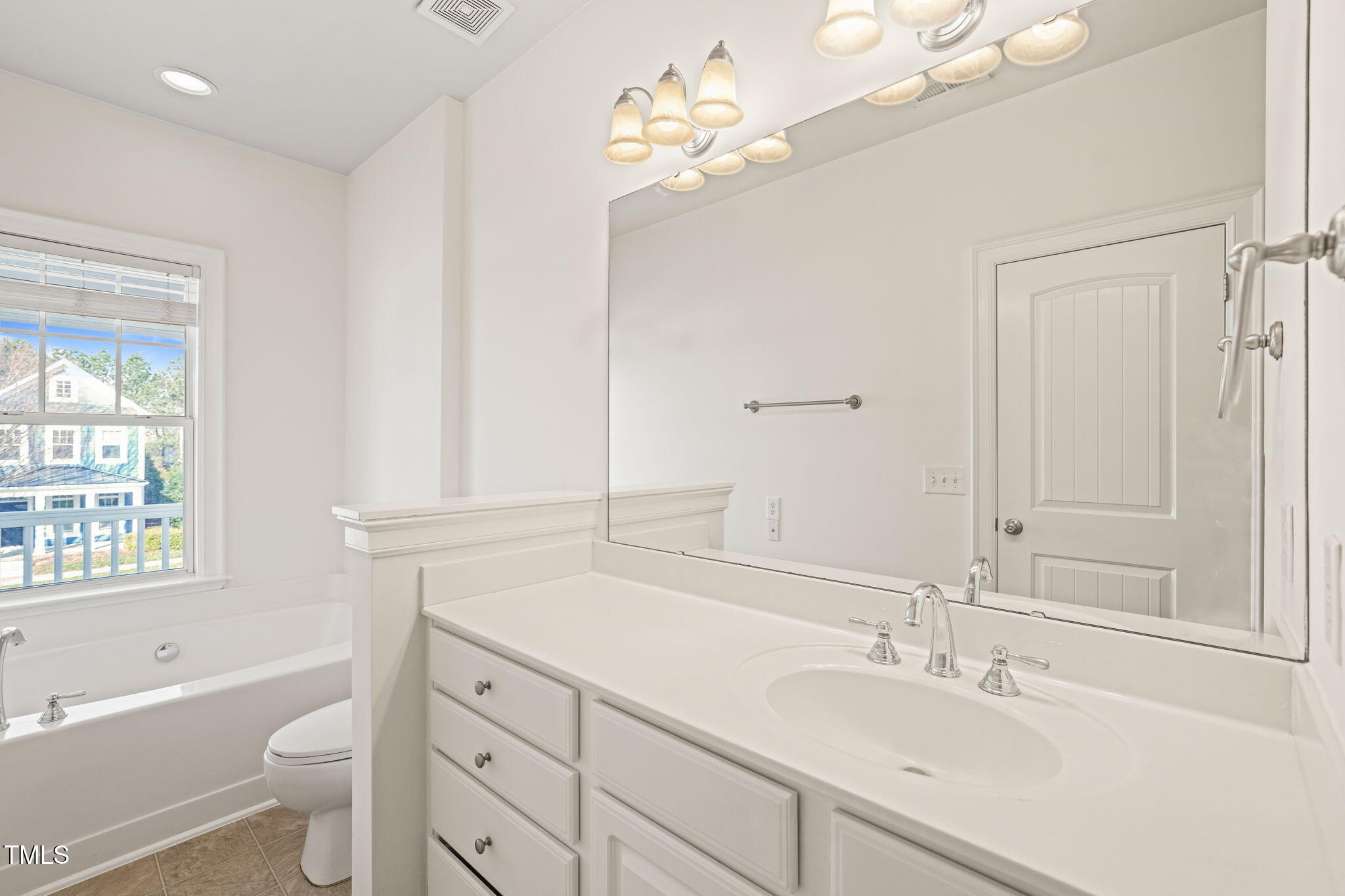 7732 ACC Boulevard Raleigh, NC 27617 - Photo 29 of 32 a bathroom with a toilet a sink a tub and a mirror