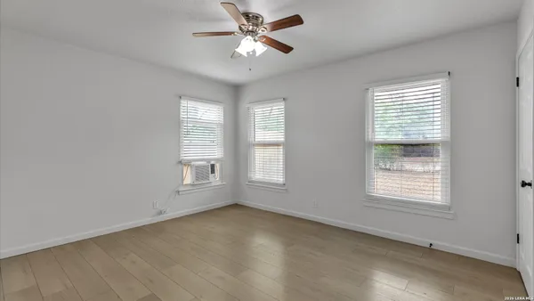 an empty room with a ceiling fan and a window
