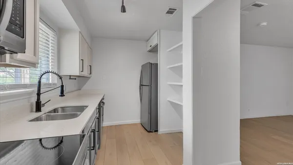 a kitchen with stainless steel appliances granite countertop a sink and refrigerator