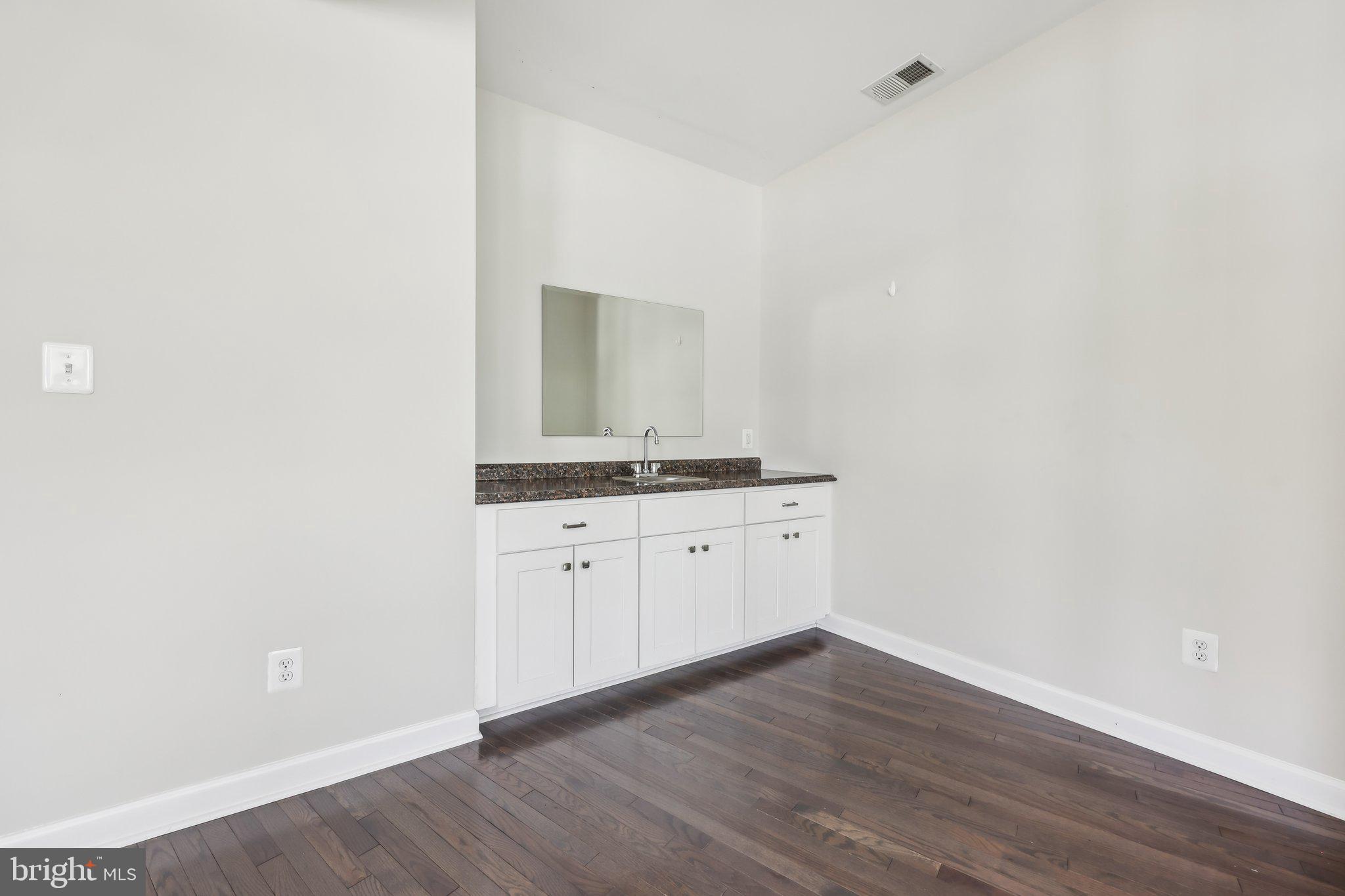 1905 South Glebe Road Arlington, VA 22204 - Photo 24 of 50 a room with wooden floor and white cabinets