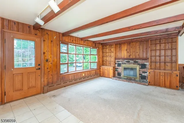 a view of an empty room with a fireplace and a window