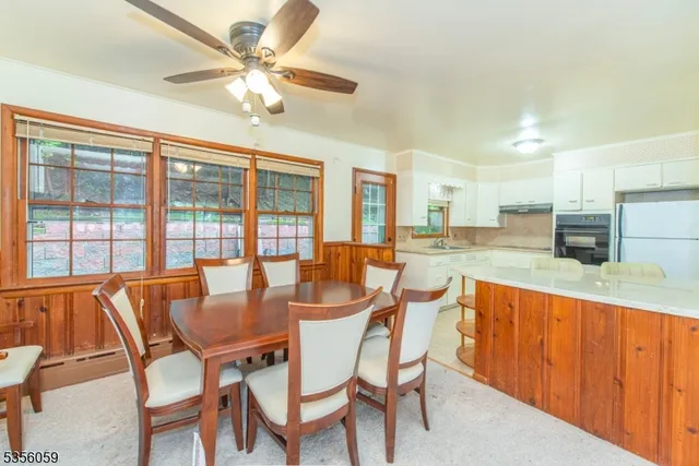 a view of a dining room with furniture a chandelier and a large window