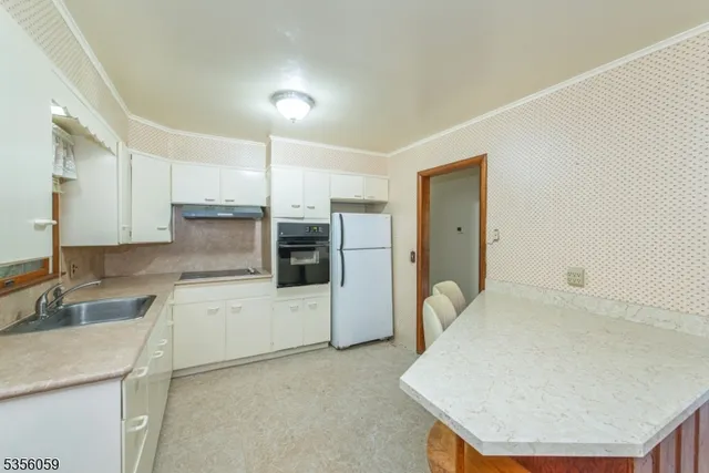 a kitchen with a sink a stove a refrigerator and cabinets