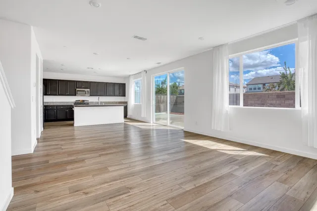 a view of a kitchen with wooden floor and a window