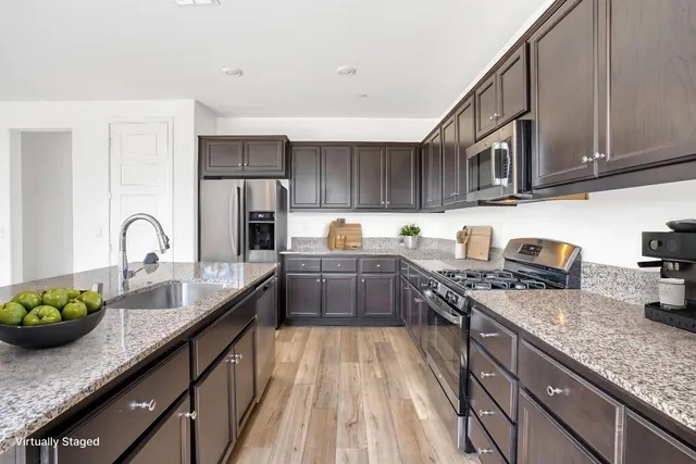 a kitchen with granite countertop a sink stainless steel appliances and cabinets