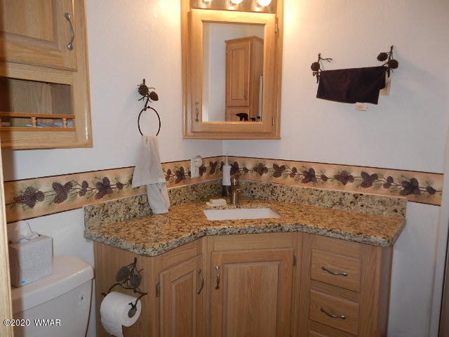 3721 Horseshoe Loop Show Low, AZ 85901 - Photo 22 of 44 a bathroom with a granite countertop sink and a mirror