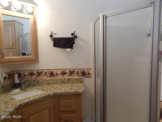3721 Horseshoe Loop Show Low, AZ 85901 - Photo 24 of 44 a bathroom with a granite countertop sink and a mirror