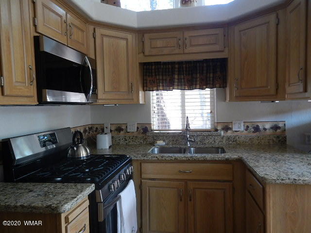 3721 Horseshoe Loop Show Low, AZ 85901 - Photo 33 of 44 a kitchen with granite countertop a sink a stove a microwave and cabinets