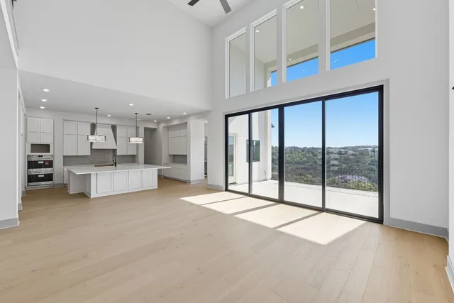a large kitchen with kitchen island a stove a sink a center island and wooden floor