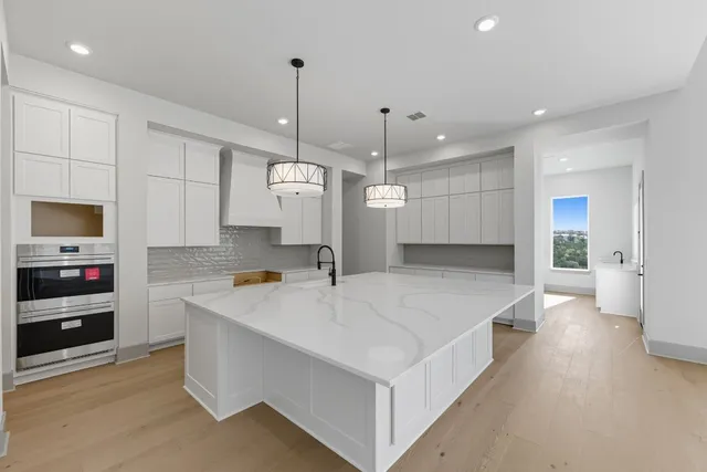 a large kitchen with stainless steel appliances kitchen island a stove a refrigerator a oven and a sink with cabinets