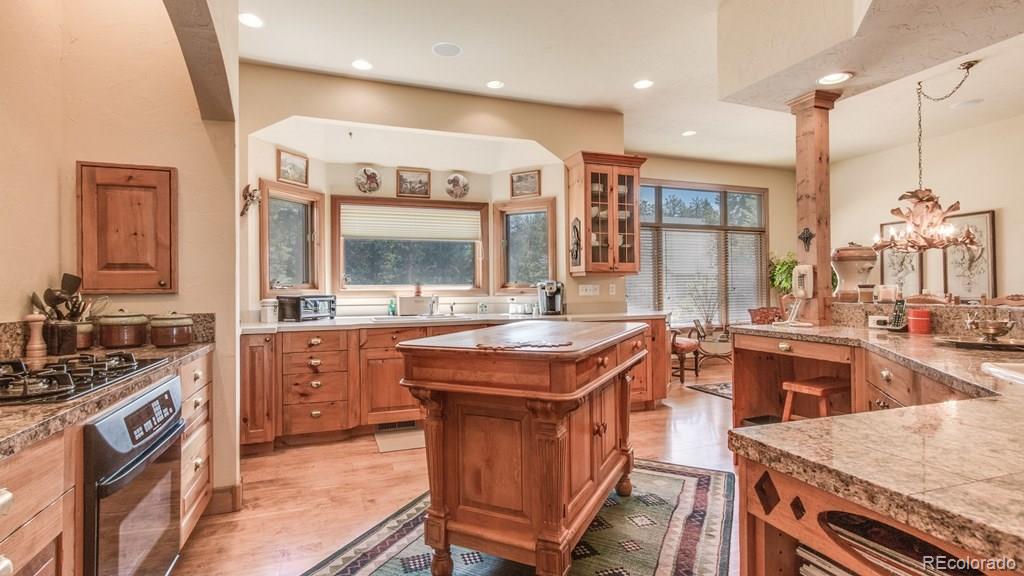 11921 South Ridge Road Conifer, CO 80433 - Photo 10 of 35 a kitchen with a stove a sink and a refrigerator