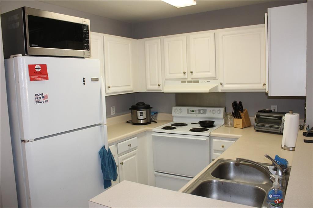 1101 Juniper Street Northeast, Unit 1416 Atlanta, GA 30309 - Photo 8 of 48 a kitchen with stainless steel appliances a refrigerator sink and white cabinets