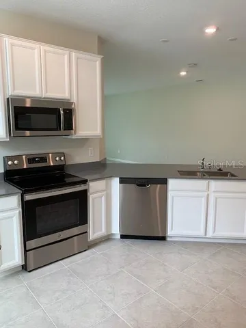 a view of a hall with kitchen and living room