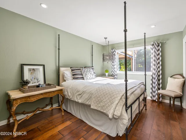 a bedroom with a bed a table and painting on the wall