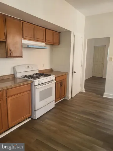 a kitchen with stainless steel appliances white cabinets and a wooden floor