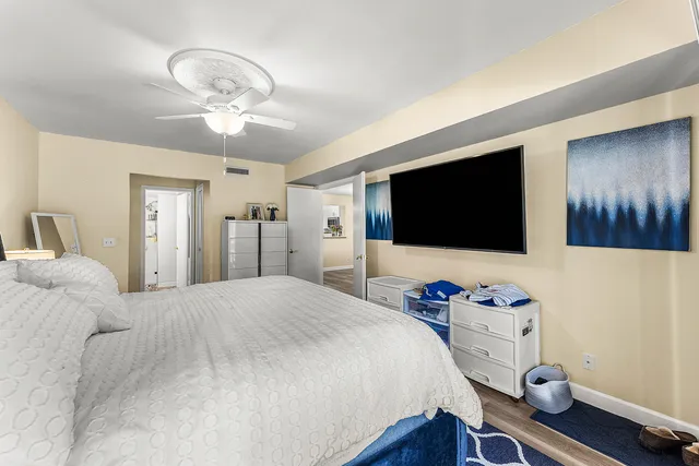 a bedroom with a bed and a flat tv screen on dresser