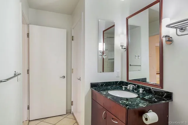 a bathroom with a granite countertop sink and a mirror