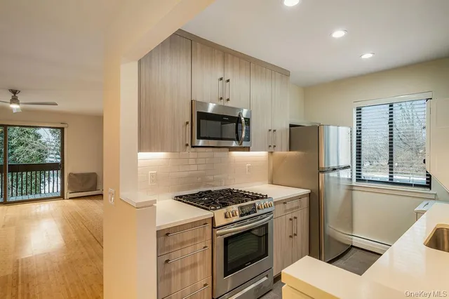 a kitchen with stainless steel appliances granite countertop a stove a sink and a refrigerator