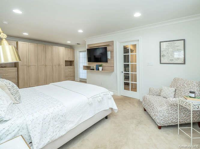 23 Ivy Way Port Washington, NY 11050 - Photo 26 of 47 a bedroom with a bed and a flat screen tv