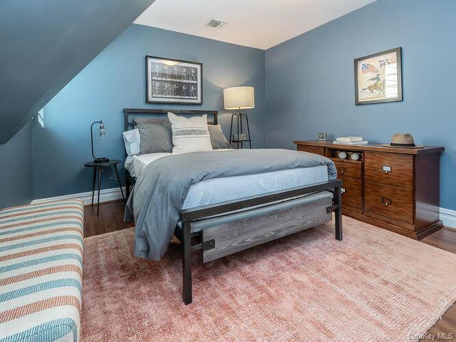 23 Ivy Way Port Washington, NY 11050 - Photo 31 of 47 a bedroom with a bed and a lamp on table