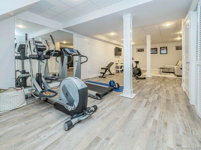 23 Ivy Way Port Washington, NY 11050 - Photo 38 of 47 a room with gym equipment and wooden floor