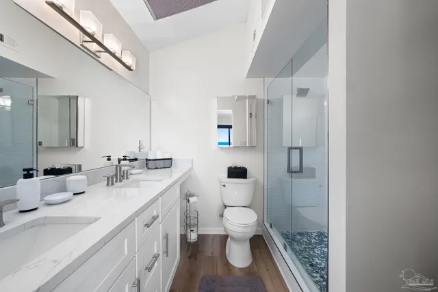 a bathroom with a sink a toilet and shower
