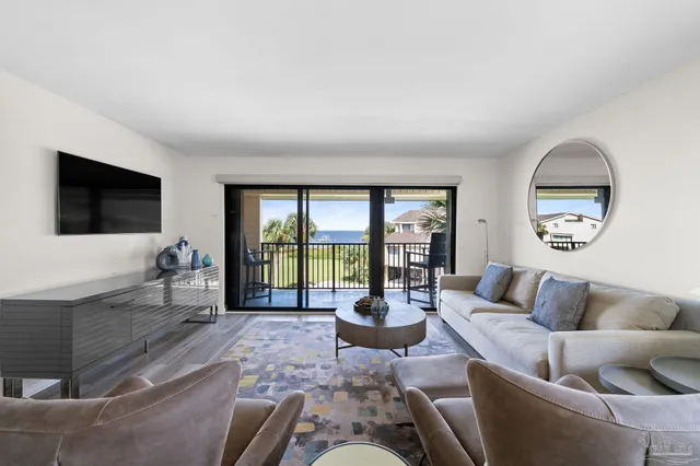 a living room with furniture large window and flat screen tv