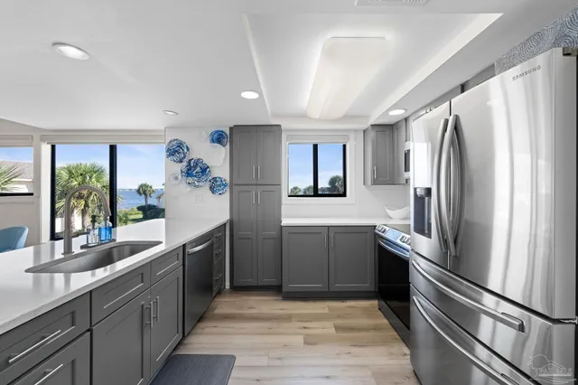 a kitchen with stainless steel appliances granite countertop a refrigerator and a sink