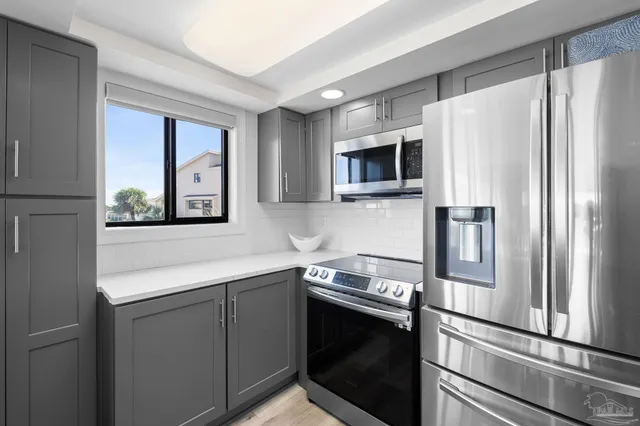 a kitchen with stainless steel appliances a refrigerator stove and microwave