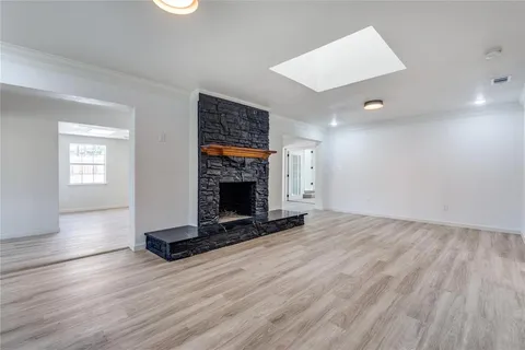 a view of empty room with wooden floor and fireplace